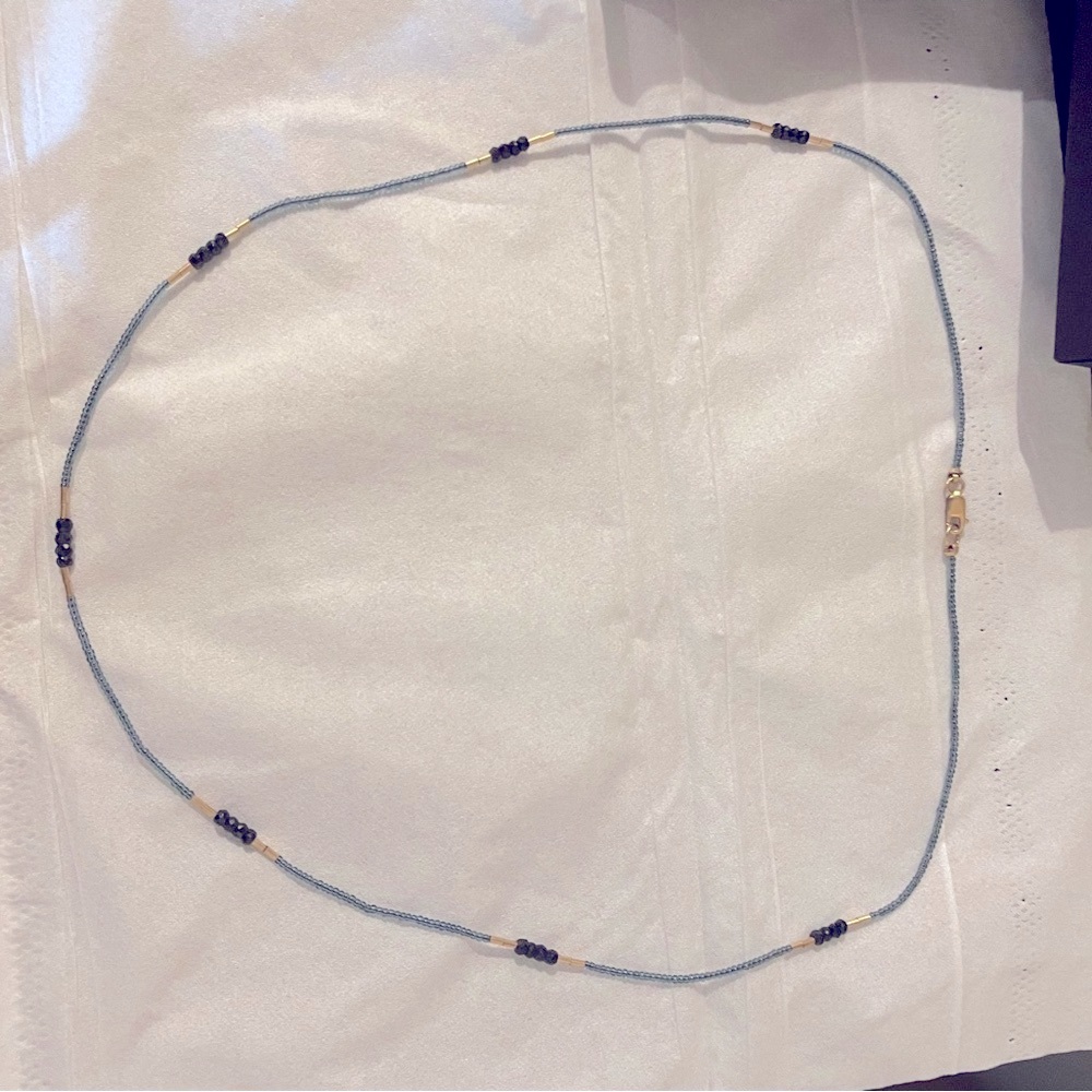 Brand new with box but no tag. Necklace gray and black.